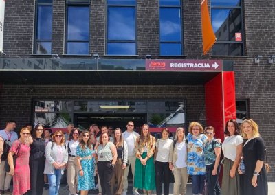 osebe stojijo pred stavbo